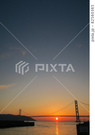 神戸フィッシャリーナから見た明石海峡大橋と夕日 82560365