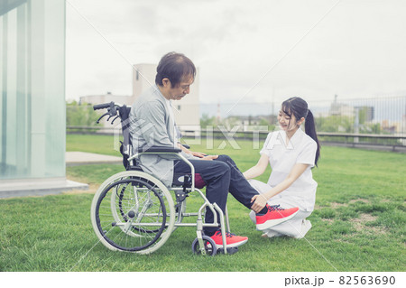 足に異変を感じる中高年男性と医療スタッフ 82563690