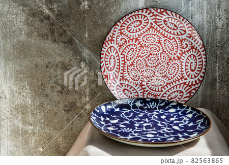 Two ceramics plates on pink table cloth. 82563865