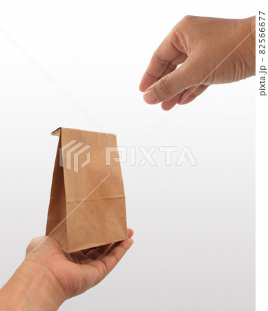 hand holding a brown paper bag hand holding a brown paper bag 82566677