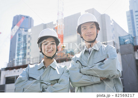 建築現場に立つ作業服の男女 82569217