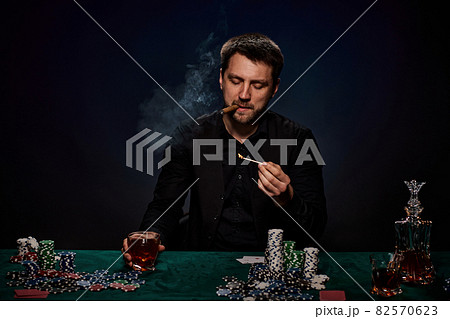 Bearded casino player man playing poker on green table 82570623