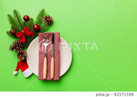 Christmas table place setting with christmas decor and plates, kine, fork and spoon. Christmas holiday background. Top view with copy space 82571508