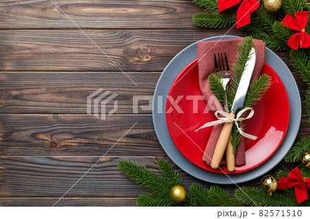 Christmas table place setting with christmas decor and plates, kine, fork and spoon. Christmas holiday background. Top view with copy space 82571510