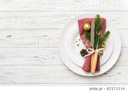 Christmas table place setting with christmas decor and plates, kine, fork and spoon. Christmas holiday background. Top view with copy space 82571514