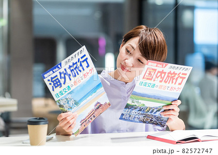 カフェで旅行のパンフレットを見る女性 撮影協力：WEEK芝大門(サンフロンティア不動産) 82572747