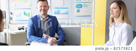 Disabled man discusses business development with business team Disabled man discusses business development with business team 82573823