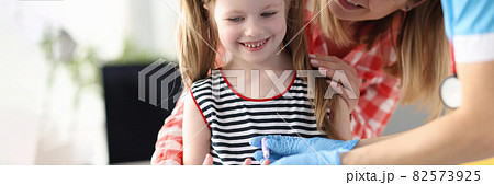 Taking blood from little girl's finger for laboratory analysis 82573925