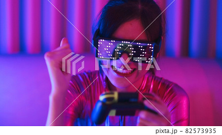 Neon  asian woman dancing. Fashion model woman in neon light, portrait of beautiful model with fluorescent make-up, Art and future design of female disco dancer posing in UV, colorful make up. 82573935