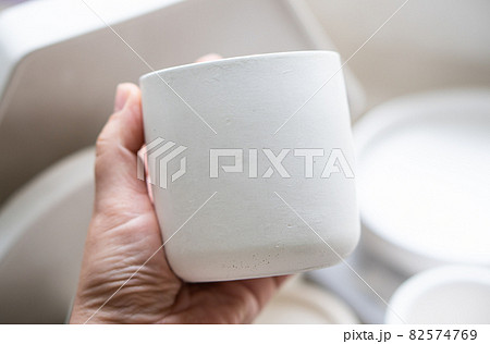 Empty blanc white concrete candle jar in artist's hand, creative painting and design ready ceramic Empty blanc white concrete candle jar in artist's hand, creative painting and design ready ceramic 82574769