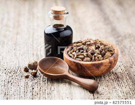 Propolis granules with tincture on wooden background Propolis granules with tincture on wooden background 82575551