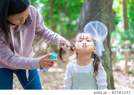 子供に虫除けスプレーをつけるお母さん 子供に虫除けスプレーをつけるお母さん 82581243