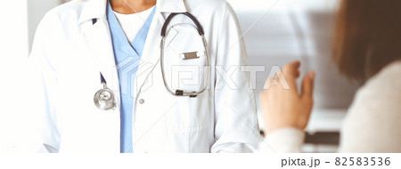 Unknown woman-doctor communicating with female patient. Physician checks medical history record and exam results, close-up. Medicine concept Unknown woman-doctor communicating with female patient. Physician checks medical history record and exam results, close-up. Medicine concept 82583536