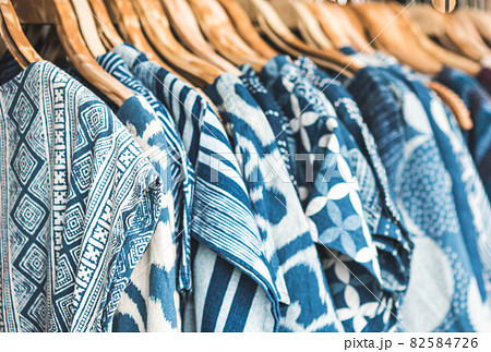 Selective focus tie dye shirts in blue white clothing hanging on rack. Selective focus tie dye shirts in blue white clothing hanging on rack. 82584726