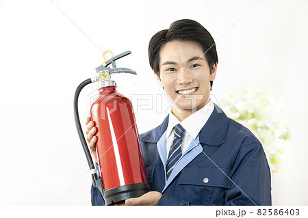 消火器を持って微笑む男性 82586403