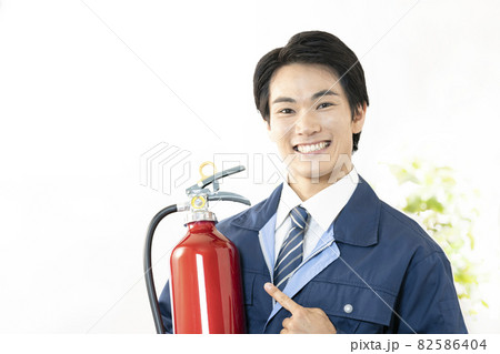 消火器を持って微笑む男性 82586404
