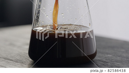 coffee pour into glass carafe on black oak table coffee pour into glass carafe on black oak table 82586438