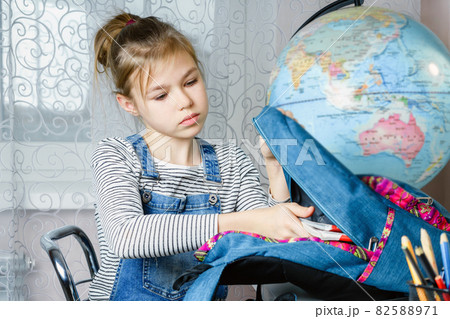 School girl packing books in backpack at the table for school after finishing homework, back to school concept School girl packing books in backpack at the table for school after finishing homework, back to school concept 82588971