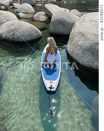 Beautiful yang lady relaxes on the paddle board Beautiful yang lady relaxes on the paddle board 82588972