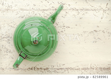 retro enameled green teapot on wooden table 82589961
