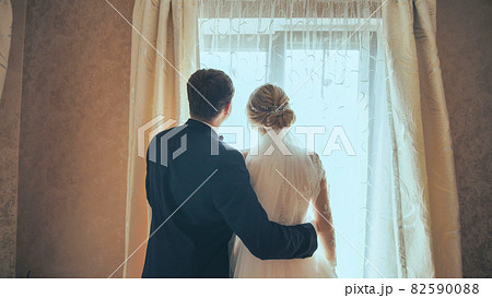 The groom approaches his young bride on their wedding day. 82590088