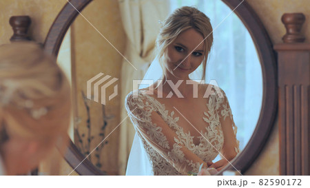 The bride at the mirror is preparing for the wedding. The bride at the mirror is preparing for the wedding. 82590172