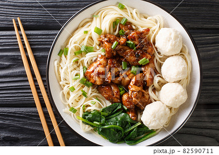 Indonesian food Mie ayam egg noodles with fried chicken meat and meatballs close-up in a bowl. horizontal top view 82590711