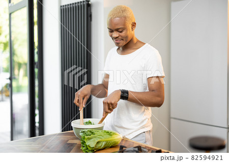 Black man cooking organic salad at home kitchen Black man cooking organic salad at home kitchen 82594921