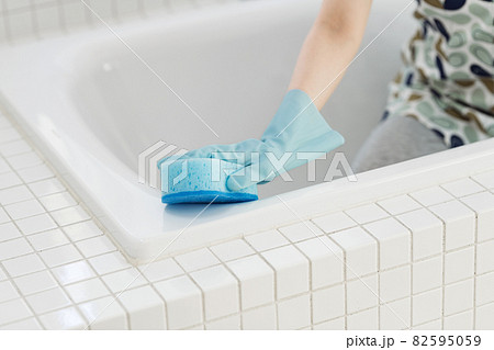 お風呂の浴槽をスポンジで掃除する女性 82595059