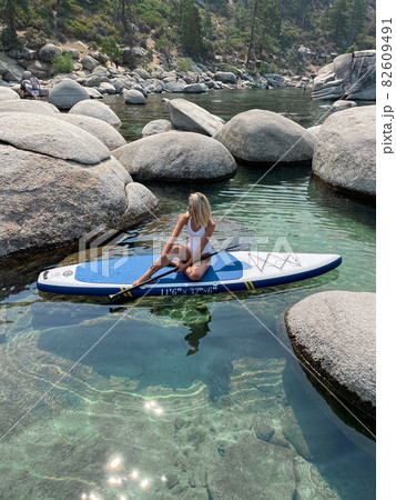 Beautiful yang lady relaxes on the paddle board  82609491