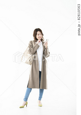 女性　スマホ　検索　全身　白バック　笑顔 82610563