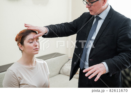 Elderly male hypnotherapist with a female patient. An alternative way to heal mental health Elderly male hypnotherapist with a female patient. An alternative way to heal mental health 82611670