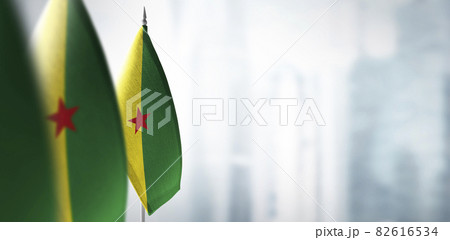 Small flags of French Guiana on a blurry background of the city 82616534