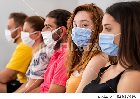 Group of people is sitting and waiting in a hall with protective face mask in social distance. pandemic and health care concept 82617496