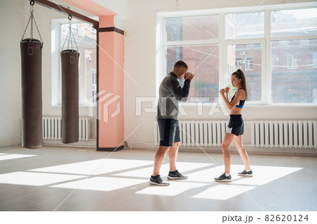 Female MMA fighter training punches technique 82620124