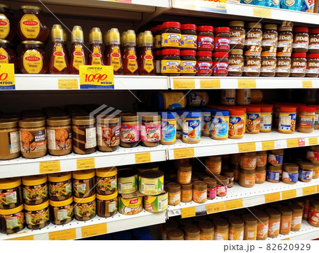 PENANG, MALAYSIA -MARCH 5, 2021: Selected focused on a variety of fruit jams displayed inside the supermarket. Sorted by the brand to facilitate customers. Tag with the price tag. PENANG, MALAYSIA -MARCH 5, 2021: Selected focused on a variety of fruit jams displayed inside the supermarket. Sorted by the brand to facilitate customers. Tag with the price tag. 82620929