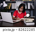 Smart asian girl child sit at table study at laptop make notes write in notebook, schoolgirl handwrite prepare homework assignment, prepare task at home, distant education concept 82622285