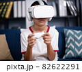 asian boy wearing virtual reality googles at home, remote education experiment, future today, new online education, indoor lifestyle. 82622291