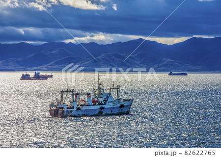 large fishing vessel on the background of hills and volcanoes. Selective focus 82622765