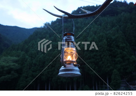 キャンプ夕暮れハリケーンランタンを灯す キャンプ夕暮れハリケーンランタンを灯す 82624255