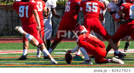 Kicker kicking a field goal during a football game 82627923