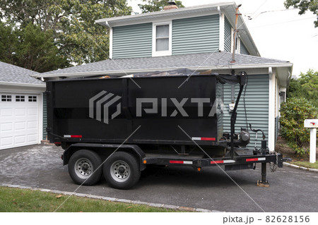Dumpster on a trailer in a residential driveway Dumpster on a trailer in a residential driveway 82628156