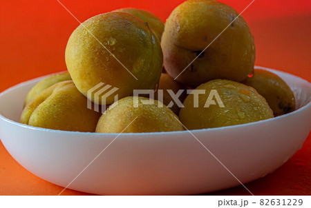 Apricot. Ripe organic apricots on an orange background. Ukraine july 2021 Apricot. Ripe organic apricots on an orange background. Ukraine july 2021 82631229