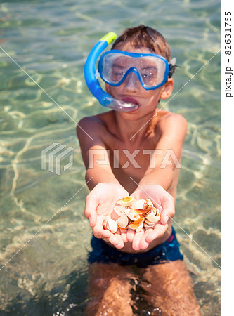 Kid showing shells 82631755