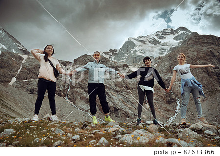 A group of friends climbed high in the mountains 82633366