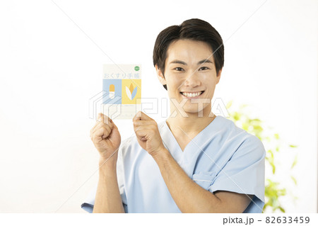 笑顔でお薬手帳を持つ薬剤師 笑顔でお薬手帳を持つ薬剤師 82633459