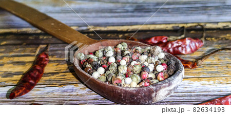 A mixture of peppers. Black, white, red polka dots. Separate on a wooden background. Selected sharpness A mixture of peppers. Black, white, red polka dots. Separate on a wooden background. Selected sharpness 82634193