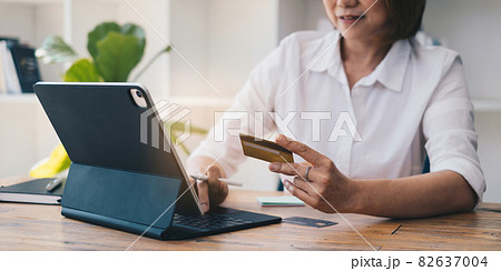 Woman enjoy with online shopping application and typing credit card for fill number to payment. 82637004