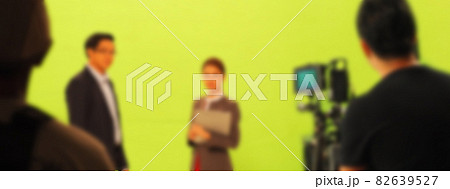 Blurry images of making TV commercial movie video in big green screen background. Film crew team working with actor. Recording by professional digital camera and lighting set. film behind the scenes Blurry images of making TV commercial movie video in big green screen background. Film crew team working with actor. Recording by professional digital camera and lighting set. film behind the scenes 82639527