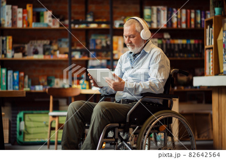 Adult disabled man in wheelchair listen to music Adult disabled man in wheelchair listen to music 82642564